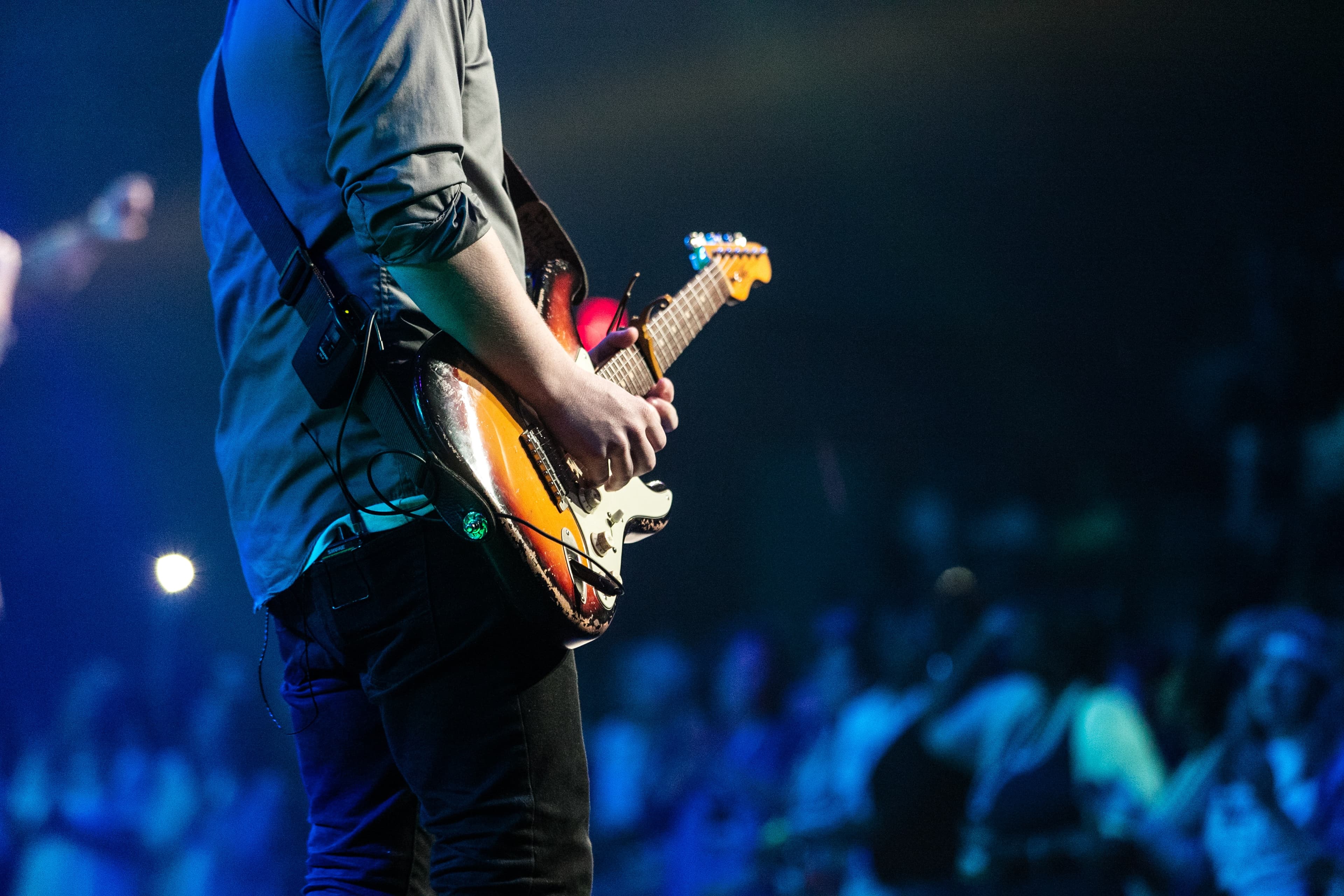 Guitarist performing on stage in front of a live audience
